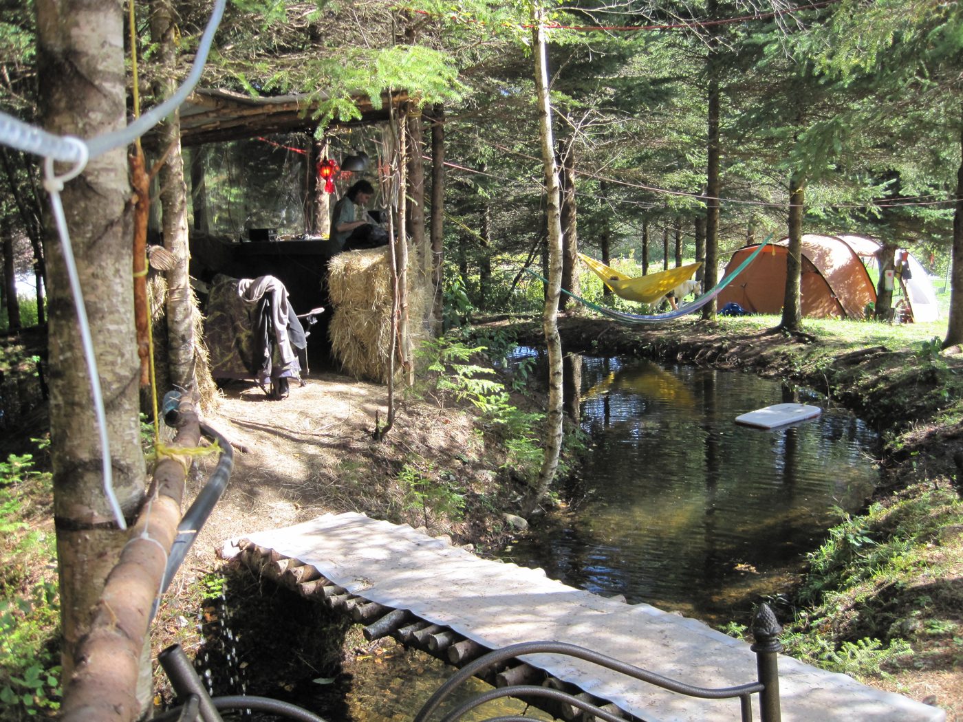 Earthdance 2010 : le camp, une tente, un hamac au-dessus de l'eau.