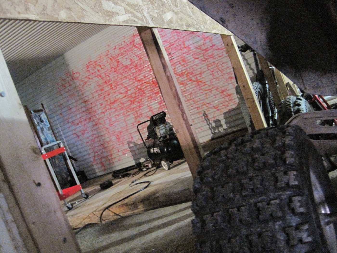 Un mur peint en rouge, un compresseur, la poussière.