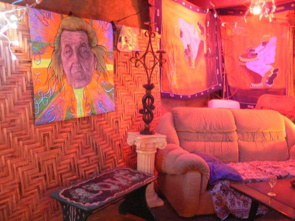 Un portrait au mur, un sofa orange, la lumière rouge.