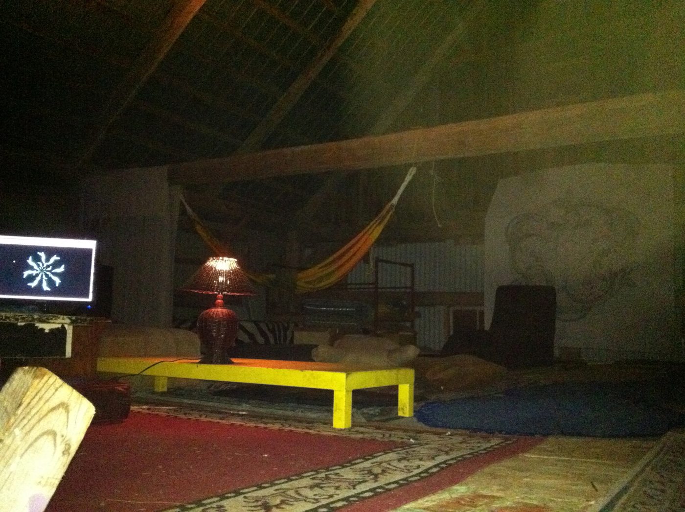 Le salon de la grange : hamacs, tapis, toiles.
