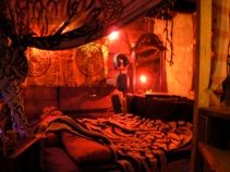 Une loge rouge, une bougie, un lit : le Donjon des origines.